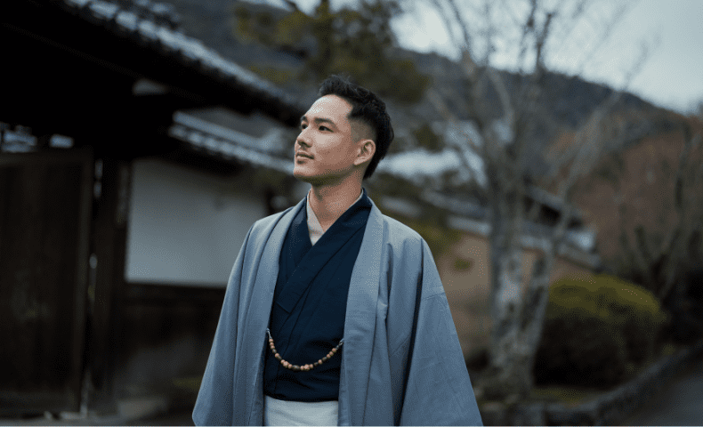 Mann vor japanischem Haus mit Haori-Himo Kette